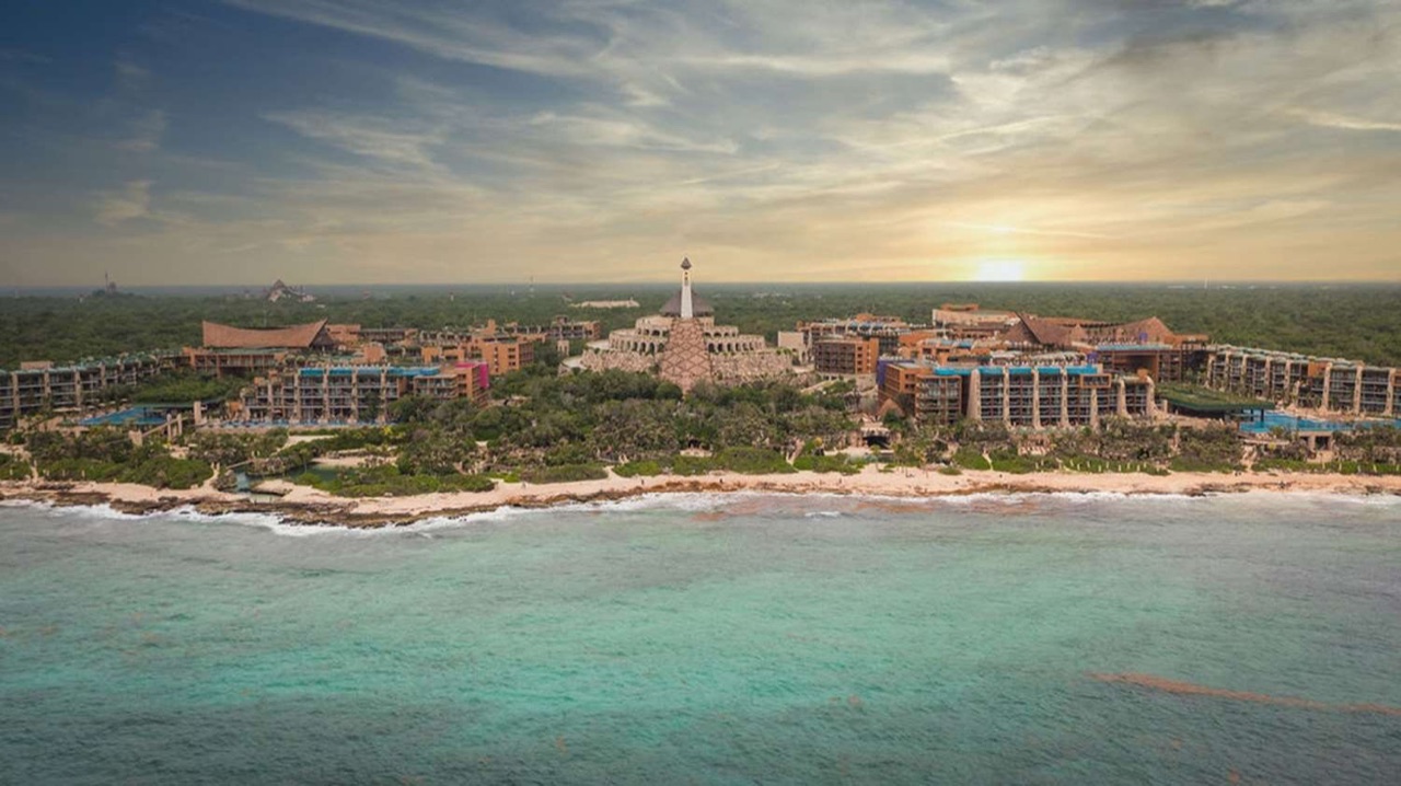Golden-hour aerial of Hotel Xcaret Arte stretching along the Caribbean coastline